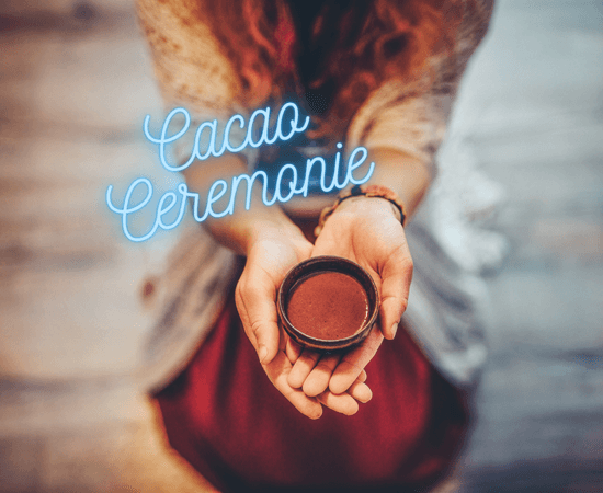 Hand die een kop ceremoniële cacao vasthoudt tijdens een. cacao ceremonie.